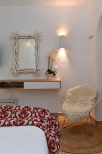 a bedroom with a bed and a mirror and a chair at Apollon Boutique Hotel in Parikia
