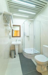 y baño con ducha, aseo y lavamanos. en Hotel Ochagof en Irkutsk