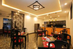 um restaurante com mesas e cadeiras e uma cozinha em Hoi An Sunny Pool Villa em Hoi An