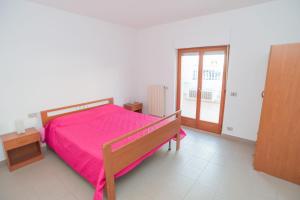 マッティナータにあるAppartamento Oleandroのベッドルーム1室(ピンクのベッドカバー付)