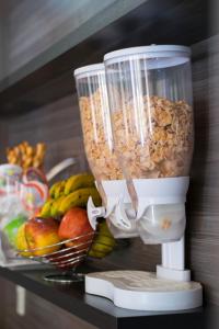 un frullatore pieno di granola accanto a un cesto di frutta di Müller Hotel a Bella Vista Altre 37 foto