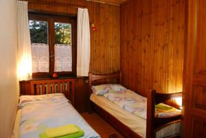 リヴィーニョにあるAppartamento Betullaのウッドウォールと窓が備わるドミトリールームのベッド2台分です。