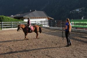 a woman is pulling a woman on a horse at Landhaus Raich in Jerzens