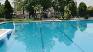 a large swimming pool with blue water at Acogedor Apart de 2 dormitorios en C.Expo, SEVILLA in Mairena del Aljarafe