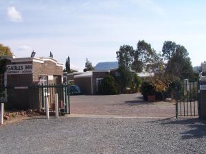 a gate in front of a house with a driveway at Gables Inn in Colesberg