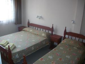 1 dormitorio con 2 camas, mesa y sillas en Hotel VIP en San Clemente del Tuyú
