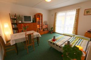 a bedroom with a bed and a table and a window at Ski Apartment in Janske Lazne