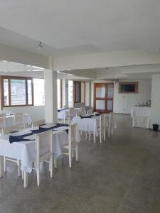 een eetkamer met witte tafels en witte stoelen bij Leal Classic Hotel in Itabuna