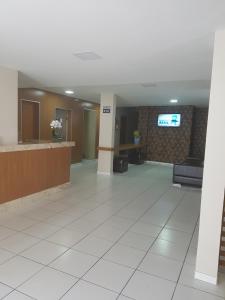 a lobby of a hospital with a tv on a wall at Leal Classic Hotel in Itabuna