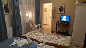 a room with a bed and a television with swans on it at Hangulat Vendégház Apartmanok in Orosháza