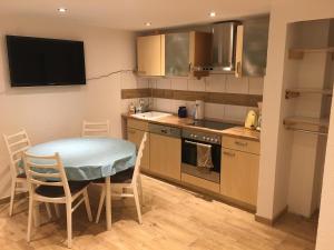 a small kitchen with a table and a table and chairs at Ferienwohnung auf dem Resthof in Aerzen