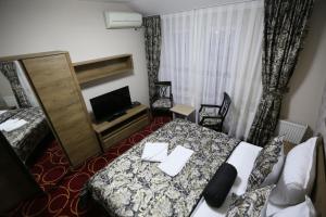 a hotel room with a bed and a television at Hotel Pejton in Pristina