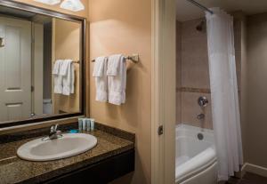 a bathroom with a shower, sink, and mirror at Executive Suites Hotel and Resort, Squamish in Squamish
