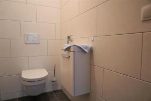 a white bathroom with a toilet and a towel at Apart Haun in Stumm