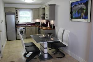 a small kitchen with a table and chairs in it at Wild Atlantic Accommodation 68 Burnside Park in Letterkenny