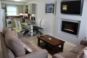 a living room with a couch and a fireplace at Wild Atlantic Accommodation 68 Burnside Park in Letterkenny