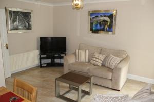 a living room with a couch and a tv at Wild Atlantic Accommodation 2G Orchard Crescent in Letterkenny