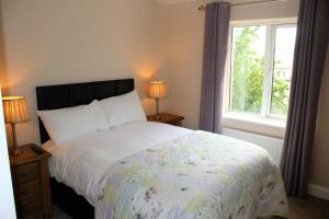 a bedroom with a large bed and a window at Wild Atlantic Accommodation 2G Orchard Crescent in Letterkenny