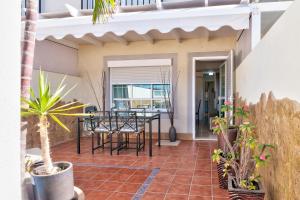 a patio with a table and chairs and potted plants at Apartamento El Valle Puerto Rico con Jacuzzi in Puerto Rico de Gran Canaria