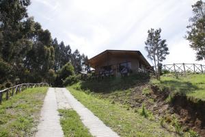 uma casa no topo de uma colina com uma estrada de terra em Turismo del Bosque em Castro