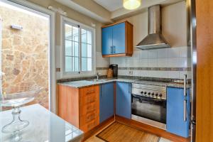 a kitchen with blue cabinets and a stove at Apartamento El Valle Puerto Rico con Jacuzzi in Puerto Rico de Gran Canaria