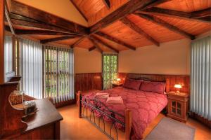 
a bedroom with a bed and a dresser at Stanley Lakeside Spa Cabins in Stanley
