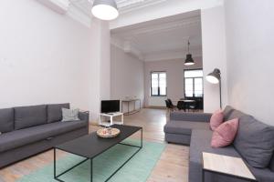 ein Wohnzimmer mit 2 Sofas und einem Tisch in der Unterkunft Parlamentarium apartment in Brüssel