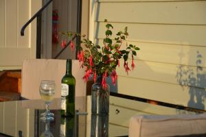 a table with a wine bottle and a vase with flowers at Kerswell Farm Shepherd Huts in Totnes