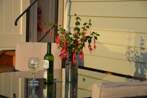 a table with a wine bottle and a vase with flowers at Kerswell Farm Shepherd Huts in Totnes +6 photos