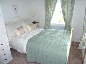 a bedroom with a bed and a window at Holme House Cottage in Oakworth