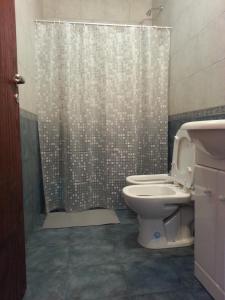 a bathroom with a shower curtain and a toilet at Bungalows Don Heraldo in San José