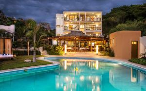 a hotel with a swimming pool in front of a building at Manta Raya Hotel - right on the beach in Cuatunalco