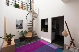 a living room with a staircase and a purple rug at Casa Dovela in Mexico City