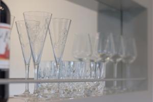 a row of wine glasses sitting on a shelf at TM Suites in Dortmund