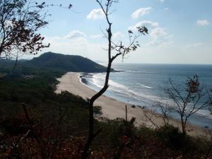a view of the beach from the top of a hill at Hotel Punta Teonoste Boutique Beachfront Resort in Popoyo