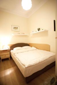 een slaapkamer met een bed en een nachtkastje met een lamp bij Apartment Charlie PERFECT PRICE in Belgrado