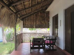 a patio with two chairs and a table on a porch at Marbella Eco Lodge in Monterrico
