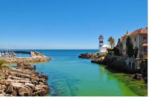 a river with a light house and a lighthouse at Belém Cozy Bedroom in Lisbon +29 photos