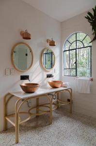 two sinks in a bathroom with two mirrors at Casa Dovela in Mexico City