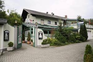 ein weißes Gebäude mit grünen Türen und einem Innenhof in der Unterkunft Gasthaus Hotel Feldschlange in Ried im Innkreis