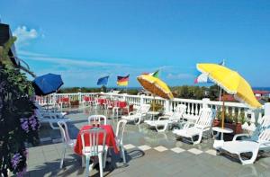 een groep stoelen en parasols op een terras bij Hotel Ristorante la Siesta in Pietrapaola