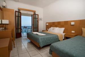 ヴァシリコスにあるVilla Contessaのベッド2台とバルコニーが備わるホテルルームです。