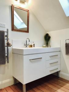 a white bathroom with a sink and a mirror at Loft Over The Vines in Richmond