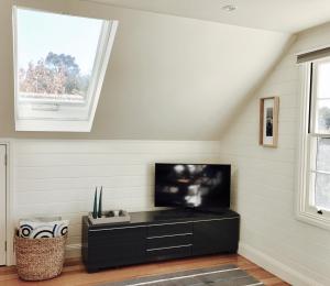 uma sala de estar com uma televisão de ecrã plano na parede em Loft Over The Vines em Richmond