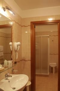 W łazience znajduje się umywalka i lustro. w obiekcie Domus Hotel w mieście Bagnoli del Trigno