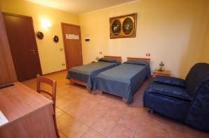 ein Wohnzimmer mit 2 Betten und einem Sofa in der Unterkunft Albergo Corte Antica in Villafranca di Verona