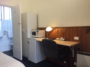 
a kitchen with a refrigerator and a microwave at Lithgow Valley Motel in Lithgow
