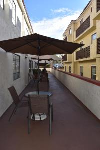a table and chairs with an umbrella on a balcony at Old Town Western Inn in San Diego