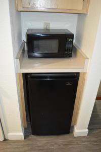 a microwave sitting on top of a counter with a refrigerator at Old Town Western Inn in San Diego