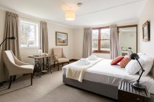 a bedroom with a bed and a table and chairs at Ratho Farm in Bothwell